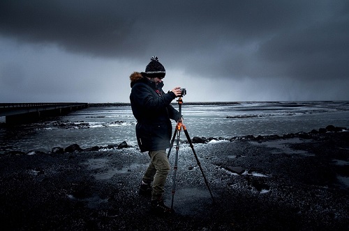 Fotografer menggunakan tripod